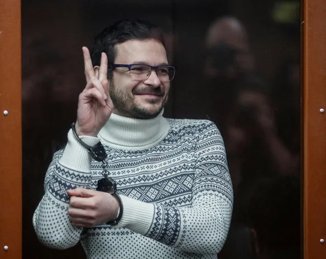 Russian opposition leader, former Moscow's municipal deputy Ilya Yashin gestures in a defendants' glass cage prior to a verdict hearing at the Meshchansky district court in Moscow, Russia, December 9, 2022. Prosecution requested nine years in prison for Yashin for spreading fake information about the Russian army. (Photo by Yuri Kochetkov/Pool via Reuters)