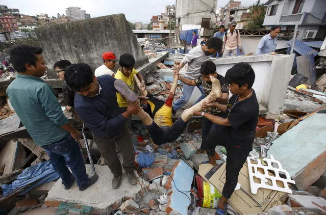 People carry the body of a victim from a damaged house after an earthquake hit, in Kathmandu, Nepal April 25, 2015. (Photo by Navesh Chitrakar/Reuters)