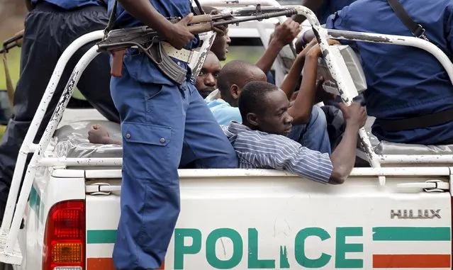 Riot police detain people participating in street protests against the decision made by Burundi's ruling National Council for the Defence of Democracy-Forces for the Defence of Democracy (CNDD-FDD) party to allow President Pierre Nkurunziza to run for a third five-year term in office, in the capital Bujumbura, April 26, 2015. (Photo by Thomas Mukoya/Reuters)