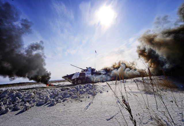 A BMP-2 amphibious infantry fighting vehicle crew competes in an individual race at a regional stage of the 2016 Tank Biathlon Competition at the Anastasyevsky training ground, March 1, 2016, Khabarovsk Territory, Russia. (Photo by Yuri Smityuk/TASS/Newscom)
