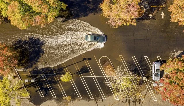 A car crosses a flooded parking lot in Oroville, Calif., on Monday, October 25, 2021. A massive storm barreled toward Southern California on Monday after causing flooding across the northern half of the state. (Photo by Noah Berger/AP Photo)