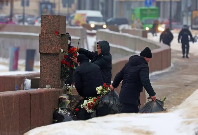 Workers remove flowers placed at the monument to the victims of political repressions in memory of Russian opposition leader Alexei Navalny, in Saint Petersburg, Russia on February 17, 2024. (Photo by Reuters/Stringer)