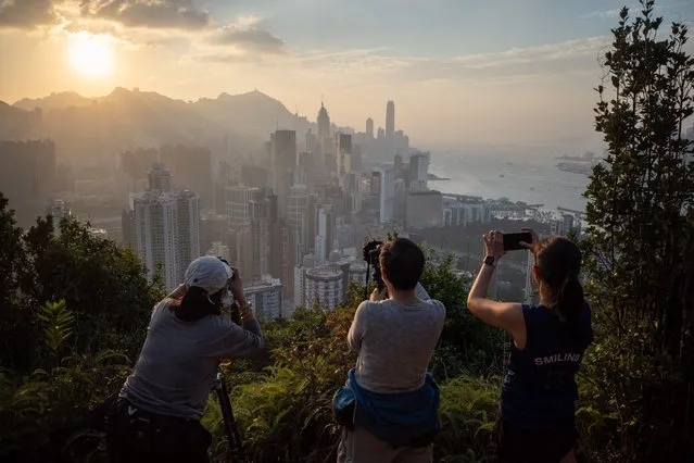 Photography enthusiasts take pictures of the setting sun over Hong Kong island in Hong Kong, China, 31 October 2021. October is month conducive to outdoor activities as the temperature averages between 19 to 28 degree Celsius and the humidity is low. (Photo by Jerome Favre/EPA/EFE)