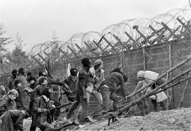 Protesters scale the fence of a construction site of a nuclear recycling power plant in Wackersdorf, West Germany, March 31, 1986. Germany is shutting down its last three nuclear power plants on Saturday, April 15, 2023, as part of an energy transition agreed by successive governments. The final countdown, delayed for several months over feared energy shortages because of the Ukraine war, is seen with relief by Germans who have campaigned against nuclear power. (Photo by Dieter Endlicher/AP Photo)