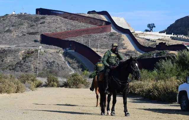 US Border Patrol police on horseback monitor the US-Mexico border fence which runs into the Pacific Ocean near Friendship Park in Imperial Beach, California on November 7, 2021, a day before the nearly 2,000 mile US-Mexico border reopens after 20 months of Covid-19 shutdown. (Photo by Frederic J. Brown/AFP Photo)