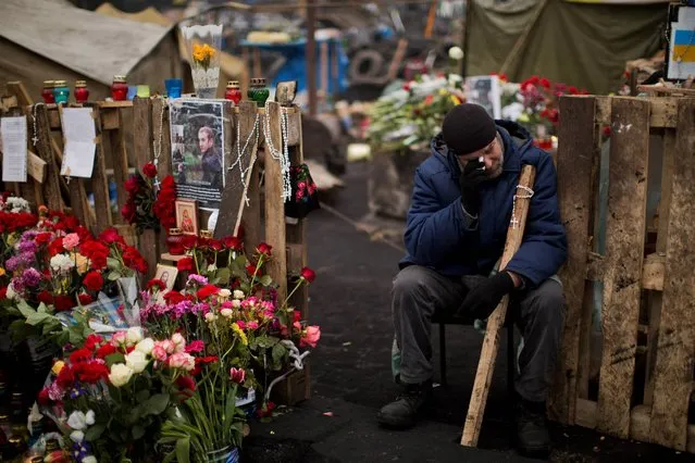 An anti-Yanukovych protester cries near a memorial for the people killed in clashes with the police at Kiev's Independence Square, the epicenter of the country's current unrest, Ukraine, Tuesday, February 25, 2014. (Photo by Emilio Morenatti/AP Photo)
