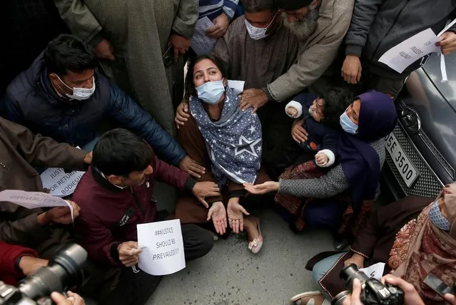 Wife of Mudasir Gull is consoled by her relatives during a protest demanding the return of the body of Mudasir, who, according to the police, was killed during a gun battle between militants and Indian security forces on Monday, in Srinagar November 17, 2021. (Photo by Danish Ismail/Reuters)