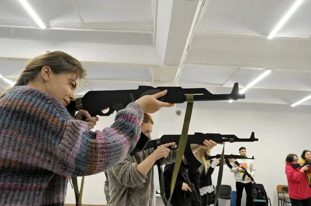 Participants learn how to handle weapons at a civilian training center on November 11, 2023 in Kharkiv, Ukraine. Since the beginning of the full-scale Russian invasion, many Ukrainians attend courses where civilians can get skills they need in times of war. One of the leading charitable organizations specializing in supporting the Armed Forces of Ukraine - the ‘Serhiy Prytula Charity Foundation’, also conducts such trainings in Ukraine. Its “Civil Awareness Center” teaches civilians basic military training – how to handle weapons, explosive devices, basics of the shooting, aerial reconnaissance basics, and premedical assistance in extreme condition. Currently, more than 31,000 Ukrainian civilians have attended the CAC trainings. (Photo by Oleksandr Lapshyn/Global Images Ukraine via Getty Images)