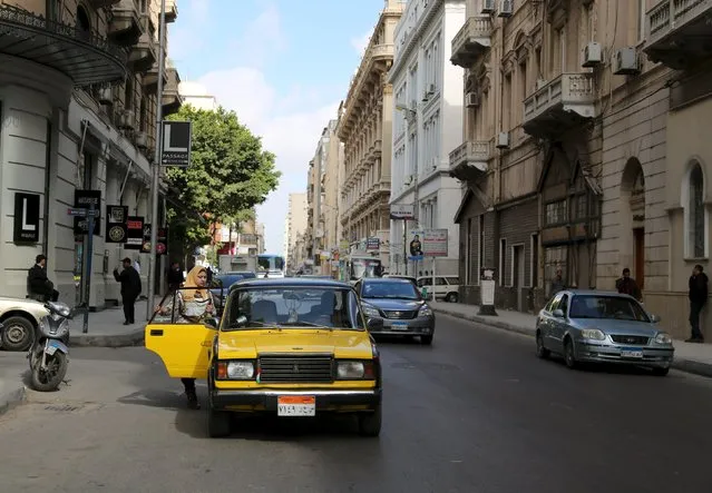A woman gets into a yellow and black cab in front of L-Passage food hall on Fouad street in Alexandria, Egypt, February 23, 2016. In Egypt's Alexandria, Fouad Street reflects the city's rich history and is known for its elegant villas and antique shops. Today the Mediterranean coastal city, once a melting pot of nationalities and faith groups, is overcrowded and dilapidated, like many of Egypt's urban centres. Fouad, among the city's oldest streets and once home to a Greek poet and a British novelist, today features modern retail brands and is an area still popular with antique fans and art lovers. (Photo by Asmaa Waguih/Reuters)