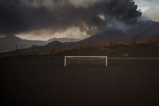 A soccer field is covered by black ashes as lava flows from the volcano, on the Canary island of La Palma, Spain on Monday, December 6, 2021. (Photo by Emilio Morenatti/AP Photo)