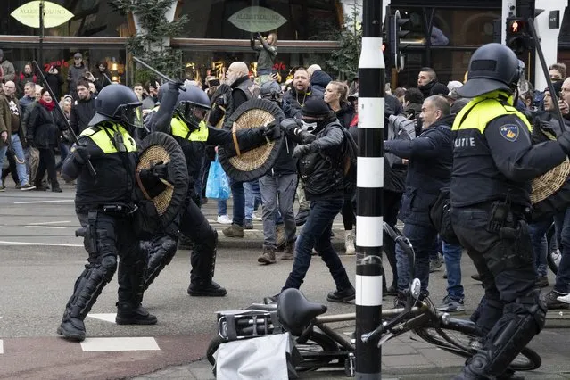 Police clash with demonstrators as thousands of people defied a ban Sunday to gather and protest the Dutch government's coronavirus lockdown measures, in Amsterdam, Netherlands, Sunday, January 2, 2022. The municipality of the Dutch capital banned the protest, saying police had indications some demonstrators could be attending “prepared for violence”. (Photo by Peter Dejong/AP Photo)