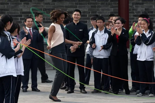 U.S. first lady Michelle Obama, center, jumps rope with Chinese schoolchildren during her visit to an ancient city wall with her daughters and her mother in Xi'an, in northwestern China's Shaanxi province, Monday, March 24, 2014. (Photo by Alexander F. Yuan/AP Photo)