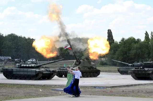 Dancers waltz in front of Russian armoured vehicles, including tanks T-72 B3, during a rehearsal for an exhibition event, part of the Army-2019 international military and technical forum, in Rostov Region, Russia on June 20, 2019. (Photo by Sergey Pivovarov/Reuters)
