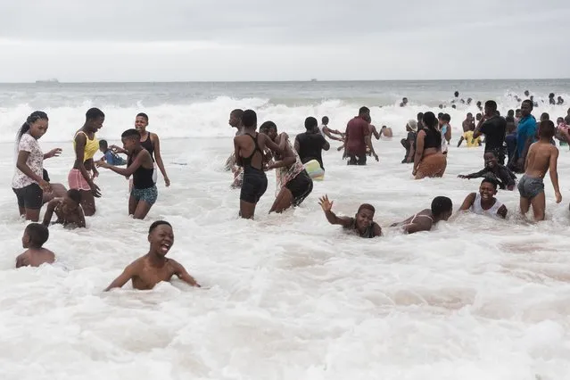 People swim in the ocean along Durban's Golden Mile beach front in Durban on December 16, 2021, amidst rising daily Covid-19 cases. (Photo by Rajesh Jantilal/AFP Photo)