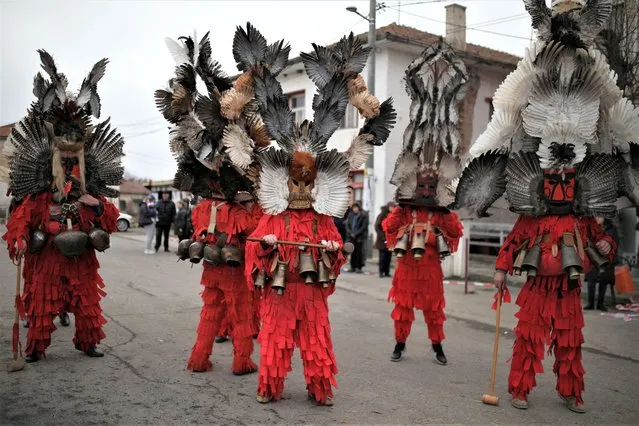 People wearing masks made of feathers participate in a winter festival in the village of Kosharevo, Bulgaria on January 14, 2023. (Photo by Stoyan Nenov/Reuters)
