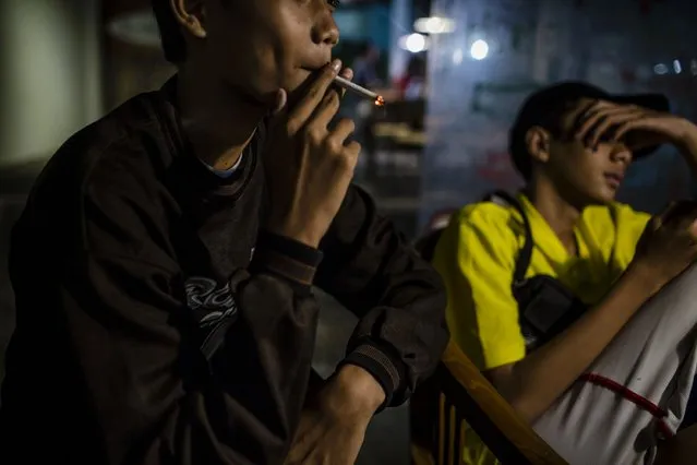 Anggit (14), smokes at a coffee shop with his friends on March 7, 2017 in Yogyakarta, Indonesia. (Photo by Ulet Ifansasti/Getty Images)
