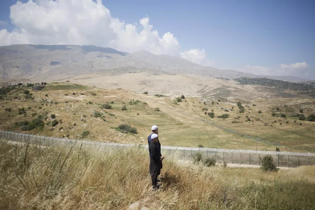 Members of Israel's Druze minority look at the the fighting between between forces loyal to Syrian President Bashar Assad and rebels in the Druze village of Khader in Syria, from the Israeli controlled Golan Heights, Tuesday, June 16, 2015. As many as 20 members of the Druze minority sect were killed last week, the deadliest violence against the Druze since Syria's conflict started in March 2011, sparking fears of a massacre against the sect. (AP Photo/Ariel Schalit)