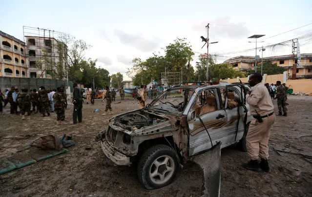 Somali security officers secure the scene of a suicide car explosion in front of the national theatre in Somalia's capital Mogadishu, March 21, 2017. (Photo by Feisal Omar/Reuters)