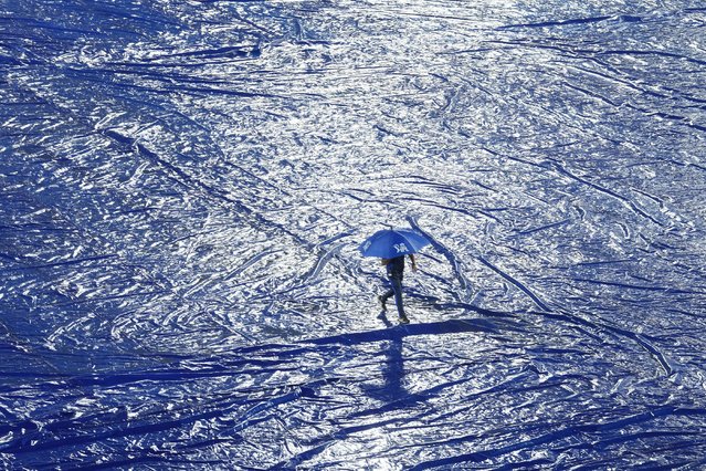 A ground staff walks with an umbrella during rain before the start of the Indian Premier League cricket match between Gujrat Titans and Sunrisers Hyderabad in Hyderabad, India, Thursday, May 16, 2024. (Photo by Mahesh Kumar A./AP Photo)