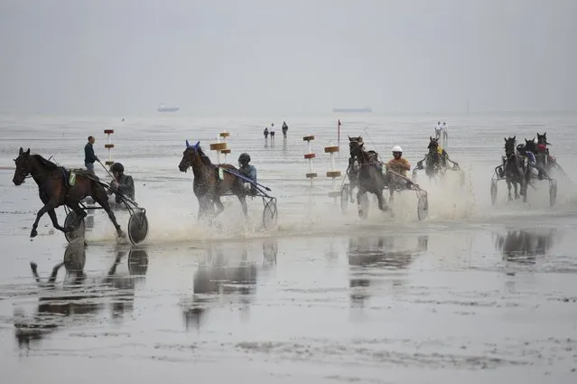 Competitors race on mud flats during their tideland race (Wadden Race) in Duhnen, Lower Saxony, Germany, July 12, 2015. (Photo by Fabian Bimmer/Reuters)