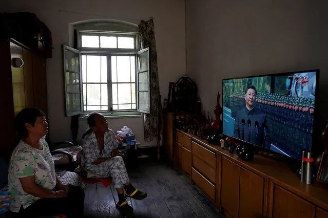 Residents watch on television Chinese President Xi Jinping reviewing troops at the military parade marking the 70th founding anniversary of People's Republic of China, from their home in Beijing, China on October 1, 2019. (Photo by Aly Song/Reuters)