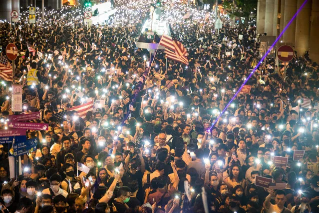 Protesters hold up the flashlights of their cellphones at a rally at Chater Garden in the the Central district in Hong Kong, China, 14 October 2019. Thousands of protesters rallied in support of the Hong Kong Human Rights and Democracy Act, which is being debated by the US Congress, marking the first legally sanctioned protest since an unpopular law banning the use of face masks at protests was introduced in September. Hong Kong has been gripped by mass demonstrations since June over a now-withdrawn extradition bill, which have since morphed into a wider anti-government movement. (Photo by Vivek Prakash/EPA/EFE)