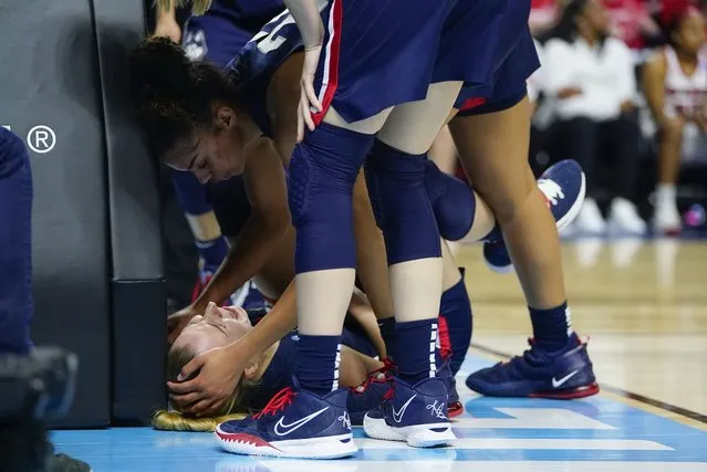 Connecticut guard Evina Westbrook (22) checks on forward Dorka Juhasz after Juhasz was injured on a play during the second quarter against NC State in the East Regional final college basketball game of the NCAA women's tournament, Monday, March 28, 2022, in Bridgeport, Conn. (Photo by Frank Franklin II/AP Photo)