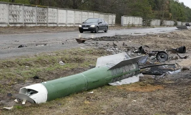 A car passes near fragments of a Russian rocket near Makariv, close to Kyiv, Ukraine, Saturday, April 9, 2022. (Photo by Efrem Lukatsky/AP Photo)