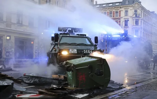 A water cannon and an evacuation tank clear a barricade on Wolfgang-Heinze-Strasse after riots broke out at the end of a left-wing demonstration, in Leipzig, Germany, Saturday, September 18, 2021. The campaign alliance “We are all Linx” had mobilized nationwide for the demonstration. (Photo by Jan Woitas/dpa via AP Photo)