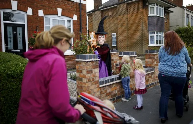 Children look at a scarecrow of characters from the "Room on a Broom" book during the Scarecrow Festival in Heather, Britain, July 28, 2015. (Photo by Darren Staples/Reuters)