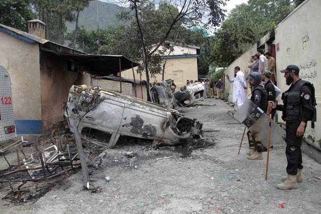 Police officers examine burnt vehicles which were torched by a Muslim mob in an attack, in Madyan in Pakistan's Khyber Pakhtunkhwa province, Friday, June 21, 2024. A Muslim mob in northwestern Pakistan broke into a police station, snatched a man who was held there and then lynched him over allegations that he had desecrated Islam's holy book, the Quran. (Photo by Naveed Ali/AP Photo)