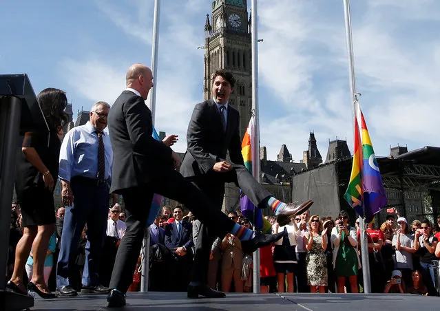 Canada's Prime Minister Justin Trudeau (R) compares socks with Liberal MP Randy Boissonnault during a pride flag raising ceremony on Parliament Hill in Ottawa, Ontario, Canada, June 14, 2017. (Photo by Chris Wattie/Reuters)