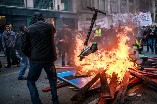 Protesters and “Gilets Jaunes” (Yellow Vests) throw scooters into a burning fire barricade during a demonstration against pension reforms lead by French Unions in Paris, France, 28 December 2019. Unions representing railway and transport workers and many others in the public sector have called for a 24th days consecutive general strike and demonstration to protest against French government's reform of the pension system. (Photo by Christophe Petit-Tesson/EPA/EFE)