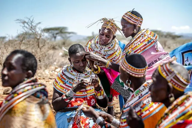A group of Samburu women work making traditional Samburu ornaments and jewelry out of beads in Sera Conservancy, Samburu County, Kenya on May 10, 2022. The bead work will be sold through the Conservancy both in the local and international market creating a profitable income for the pastoralists Samburu families that have seen their traditional lifestyle threatened due to climate anomalies and the deterioration of rangelands. (Photo by Luis Tato/AFP Photo)