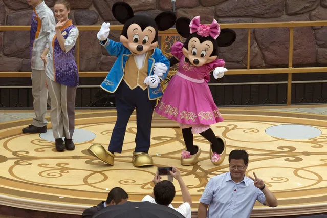 Mickey and Minnie Mouse pose for a photograph at the opening ceremony for the Disney Resort in Shanghai, China, Thursday, June 16, 2016. Walt Disney Co. opened its first theme park in mainland China on Thursday at a ceremony that mixed speeches by Communist Party officials, a Chinese children's choir and actors dressed as Sleeping Beauty and other Disney characters. (Photo by Ng Han Guan/AP Photo)