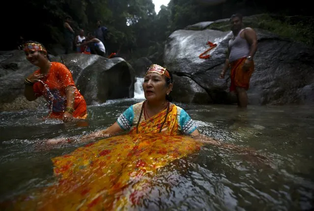 A Hindu devotee takes a holy dip while participating in the “Bol Bom” pilgrimage in Kathmandu August 10, 2015. (Photo by Navesh Chitrakar/Reuters)