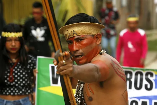 An indigenous man aims an arrow during a protest against the disappearance of Indigenous expert Bruno Pereira and freelance British journalist Dom Phillips, in Atalaia do Norte, Vale do Javari, Amazonas state, Brazil, Monday, June 13, 2022. Brazilian police are still searching for Pereira and Phillips, who went missing in a remote area of Brazil's Amazon a week ago. (Photo by Edmar Barros/AP Photo)