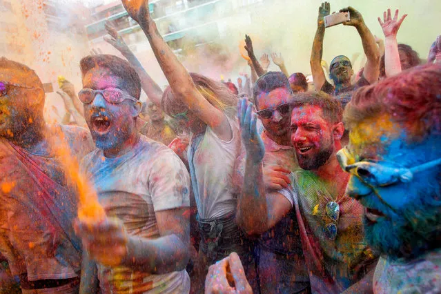 People take part in the fourth edition of the Monsoon Holi Madrid party at the multicultural district of Lavapies, in Madrid, Spain, 05 August 2017. Participants were prayed with thousands of liters of water, tinted with 600 kgs of colored powder. (Photo by EPA/Mariscal)