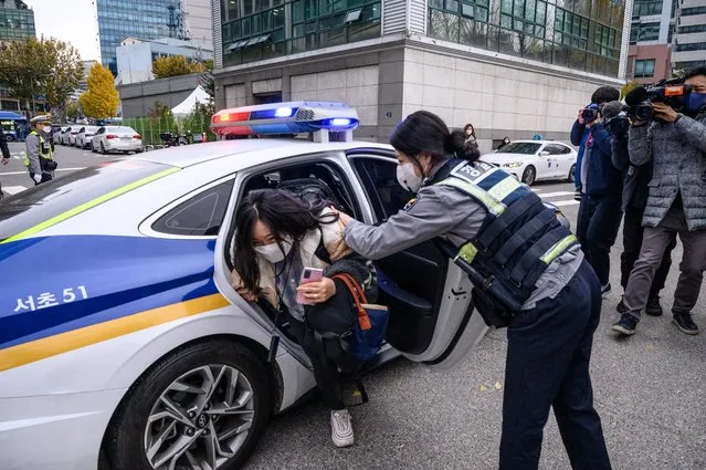 A student arrives with a police escort to sit for the annual university entrance exams outside the Ehwa Girls Foreign Language High School in Seoul on November 18, 2021. About 510,000 high school seniors and graduates across the country are expected to take the College Scholastic Ability Test. (Photo by Anthony Wallace/AFP Photo)
