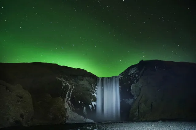 Aurora Borealis, the Northern Lights, over Skogafoss waterfall in Southern Iceland as it begins to freeze on October 29, 2019. (Photo by Owen Humphreys/PA Images via Getty Images)