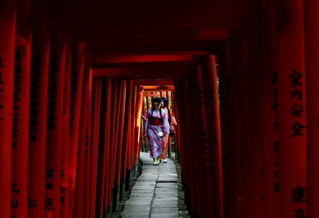 Women dressed in yukata, casual summer kimonos, walk through torii gates at the Nezu shrine in Tokyo, Japan on August 22, 2017. (Photo by Kim Kyung-Hoon/Reuters)