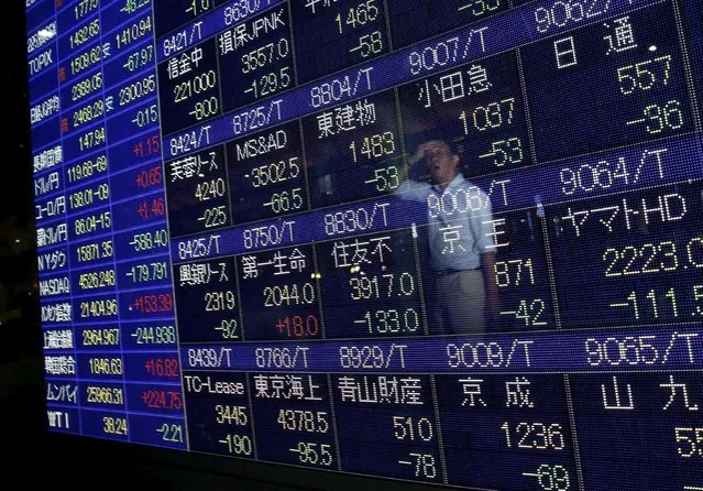 A man is reflected on a display showing stock quotation board outside a brokerage in Tokyo August 25, 2015. Volatile global markets showed tentative signs of a respite from the recent blood-letting on Tuesday as bargain hunters helped Asian stocks off three-year lows, though share markets in China, epicenter of the rout, suffered another big sell-off. (Photo by Issei Kato/Reuters)