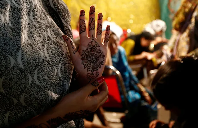 Women get Henna tattoos (Mehndi) ahead of Eid al-Fitr, which marks the end of the Muslim holy fasting month of Ramadan, at a market in Islamabad, Pakistan July 6, 2016. (Photo by Caren Firouz/Reuters)