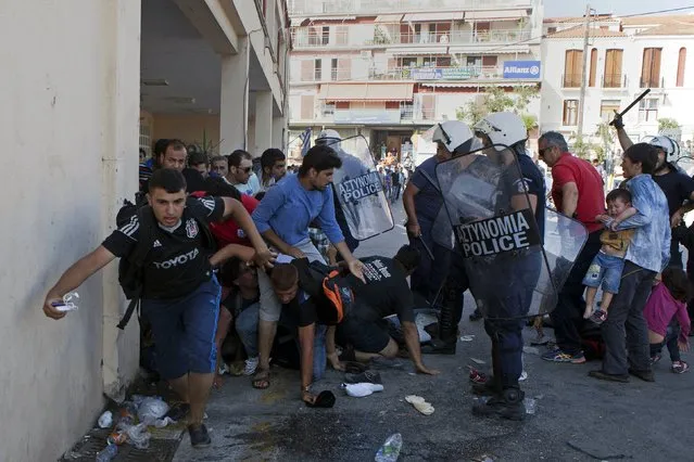 Greek riot police officers disperse Afghan refugees who protested over priority for a registration procedure at the port of Mytilene on the Greek island of Lesbos, September 6, 2015. Greece is struggling to cope with the hundreds of migrants and refugees from the war in Syria making the short crossing every day from Turkey to Greece's eastern islands, including Kos, Lesbos, Samos and Agathonisi. (Photo by Dimitris Michalakis/Reuters)