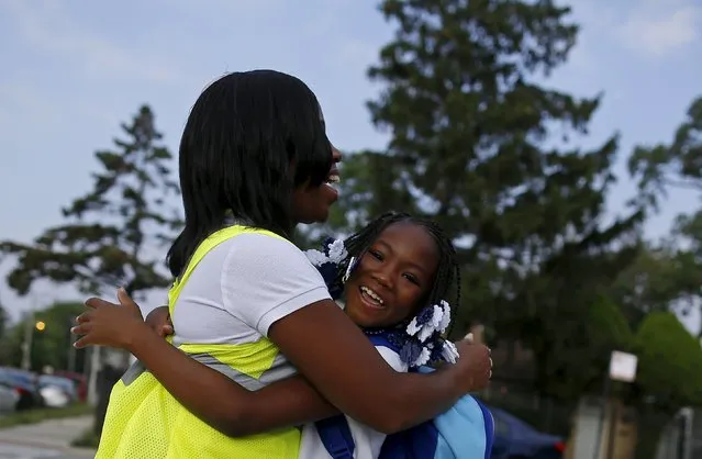 Safe Passage worker Irene Fonder gets a hug from a Sherwood Elementary School student in the Englewood neighborhood in Chicago, Illinois, United States, September 8, 2015. The fourth-largest U.S. public school system is not cutting corners when it comes to the $17.8 million annual budget for safety patrols that watch over children walking to school through neighborhoods plagued by gang violence. (Photo by Jim Young/Reuters)