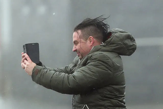 A man take selfie in the high wind at Lahinch on the west coast of Ireland  Monday October 16, 2017, as the remnants of  Hurricane Ophelia begins to hit Ireland and parts of Britain. Ireland's meteorological service is predicting wind gusts of 120 kph to 150 kph (75 mph to 93 mph), sparking fears of travel chaos. Some flights have been cancelled, and aviation officials are warning travelers to check the latest information before going to the airport Monday. (Photo by Niall Carson/PA Wire via AP Photo)
