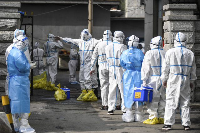 In this May 17, 2020, photo released by Xinhua News Agency, medical workers wait to be disinfected as they line up to submit the COVID-19 samples for nucleic acid test at the center for disease control and prevention in Fengman District of Jilin City in northeastern China's Jilin Province. Authorities have tightened restrictions in parts of Jilin province in response to a local cluster. (Photo by Yan Linyun/Xinhua via AP Photo)