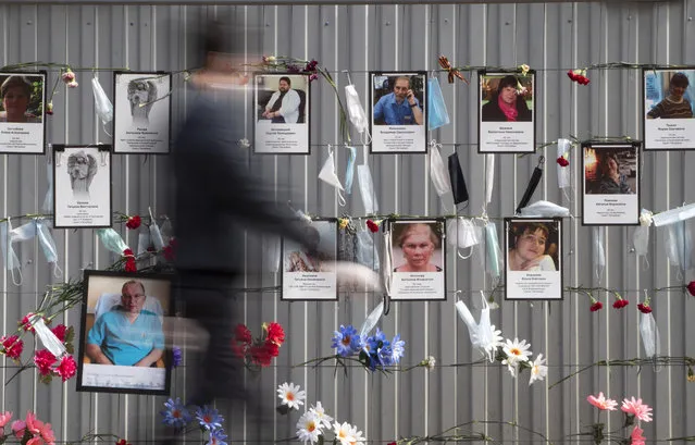 Medical face masks and portraits of St.Petersburg's medical workers who died from coronavirus infection during their work, hang at a unofficial memorial in front of the local health department in St.Petersburg, Russia, Thursday, May 14, 2020. (Photo by Dmitri Lovetsky/AP Photo)