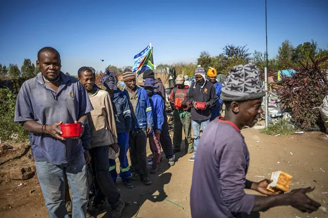 Local residents wait in a queue during a food handout by the Hennops River Revival NGO at a trash recycling area on day 61 of the national lockdown as a result of Covid-19 Coronavirus, Pretoria, South Africa, 27 May 2020. The recycling area is called 'Mushroom Farm' and is home to both South African and Besotho people who collect rash for recyling. Food insecurity is one of the main issues facing the country since the start of lockdown.  The country is at level 4 of the national lockdown in its 61 day after it was implemented on 30 April 2020. (Photo by Kim Ludbrook/EPA/EFE/Rex Features/Shutterstock)