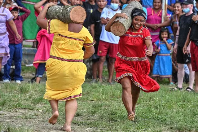 A Panamanian Gnabe (L) and Bugle (R) indigenous women compete in the Log race during the third ancestral indigenous games in Pueblo Nuevo Buri, province of Bocas del Toro, Panama on December 18, 2021. At least 250 indigenous from Panama's seven ethnic groups are fighting not only to win a medal in the Ancestral Indigenous Games, but also to rescue and perpetuate the customs and traditions of their communities. (Photo by Luis Acosta/AFP Photo